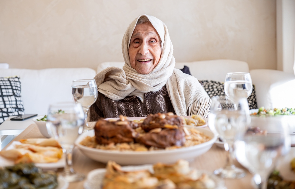 when is Eid al-Adha? An elderly lady enjoys a heartly meal with her family